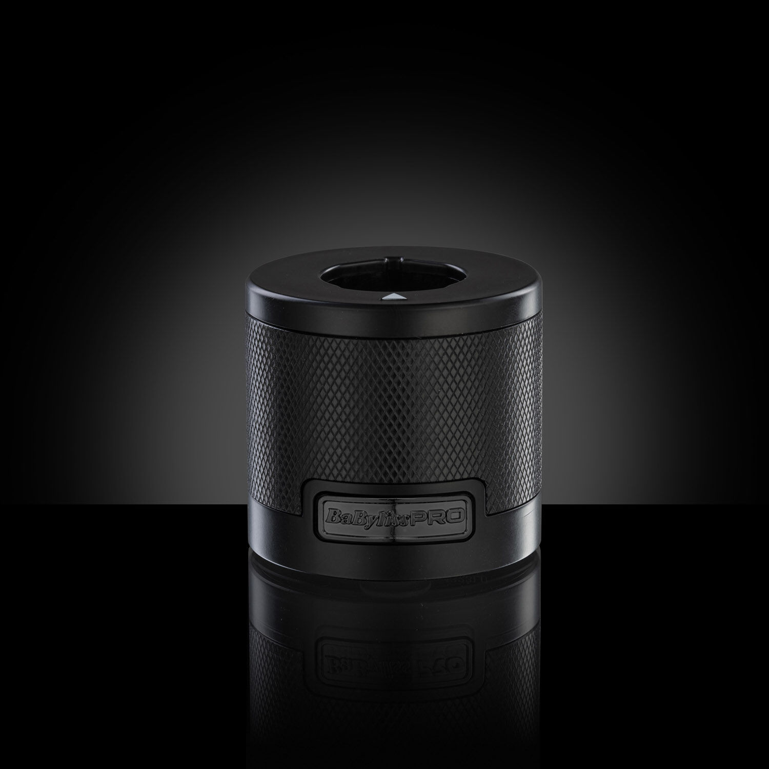 Black Dual-voltage universal battery charging base on a dark background